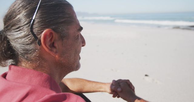 Happy senior caucasian man sitting on beach - Download Free Stock Photos Pikwizard.com