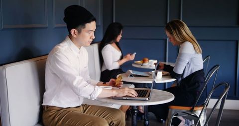 Professionals in Modern Café Using Technology and Relaxing