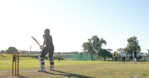 Batter preparing to face delivery on sunny community cricket pitch