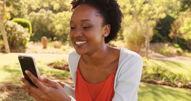 Smiling African Woman Using Smartphone in Sunny Park - Download Free Stock Images Pikwizard.com