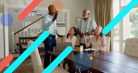 Diverse multigenerational family discussing plans at dining table with laptop and speaker