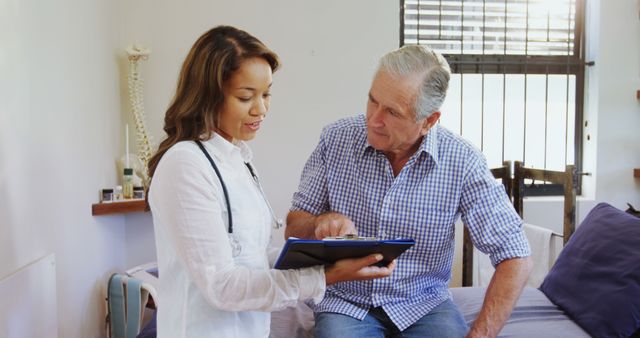 Young female doctor discussing health concerns with a senior male patient in a clinic. Ideal for use in healthcare promotion, medical presentations, elderly care, patient treatment materials, and educational purposes about doctor-patient communication.