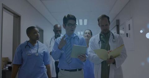 Healthcare Team Discussing Medical Rounds in Hospital Corridor