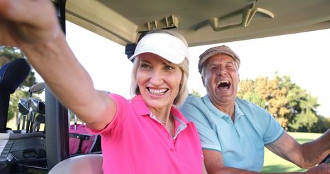 Happy Senior Golfing Couple Enjoying Day at Golf Course in Cart