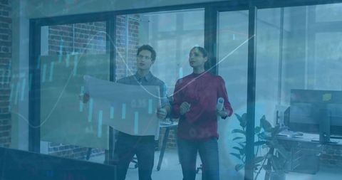 Creative team reviewing blueprints in glass office with data chart overlay