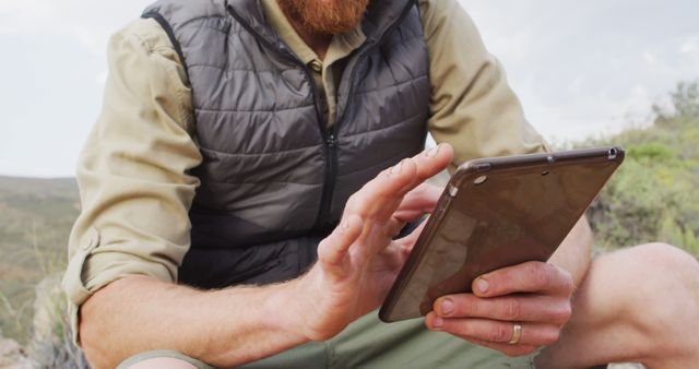 Bearded Man Using Tablet in Outdoor Wilderness Setting - Download Free Stock Images Pikwizard.com