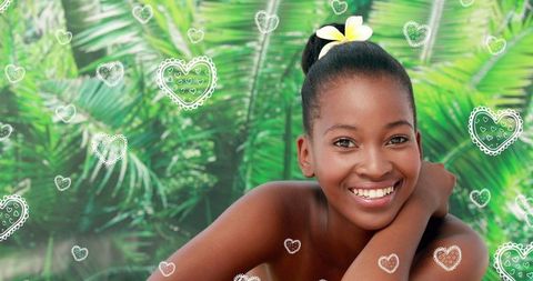 Smiling Woman with Orchid in Tropical Spa Setting