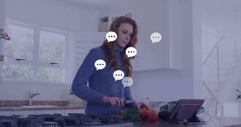 Caucasian woman using tablet for cooking instructions in modern kitchen