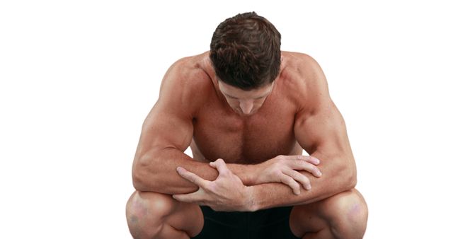 Muscular man crouching and resting after an intense workout, showcasing strength and muscles. Ideal for use in fitness, health, and wellness promotions or motivational content regarding fitness and muscle building.
