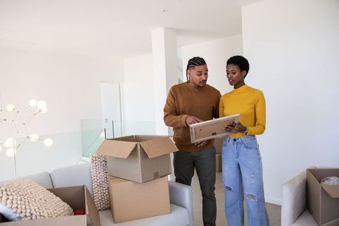 Couple Unpacking Moving Boxes in Modern Home Living Room