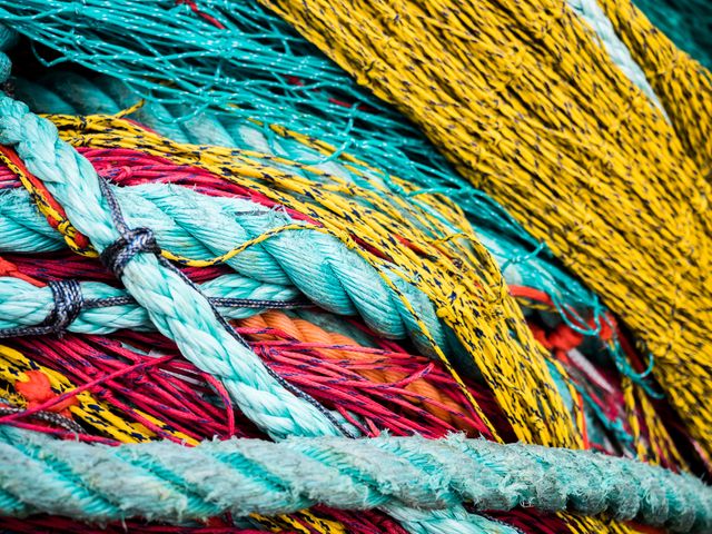 Bright and colorful close-up showing various ropes with intricate and different textures bundled together. Useful for illustrating concepts of industry, craftsmanship, textiles, or marine activities. Great for use in presentations, advertising, backgrounds for creative projects, and displays in educational materials.