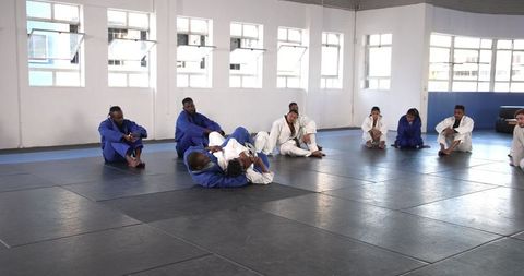 Martial Arts Students Practicing Grappling in Dojo