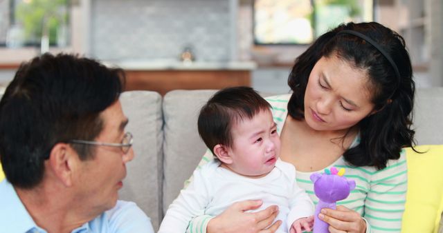 Parents Comforting Crying Baby on Couch at Home - Download Free Stock Images Pikwizard.com