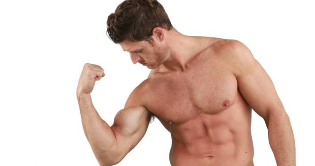 A young Caucasian man is flexing his bicep, showcasing his muscular physique, with copy space. His expression of focus and the display of strength emphasize the importance of fitness and physical health.