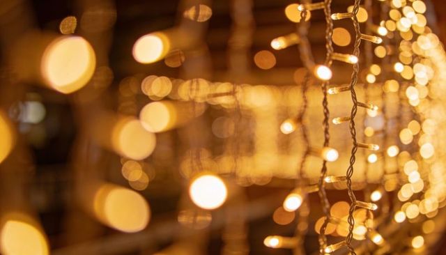 Glowing warm golden bokeh from twisted string lights curtain with vertical led bulbs