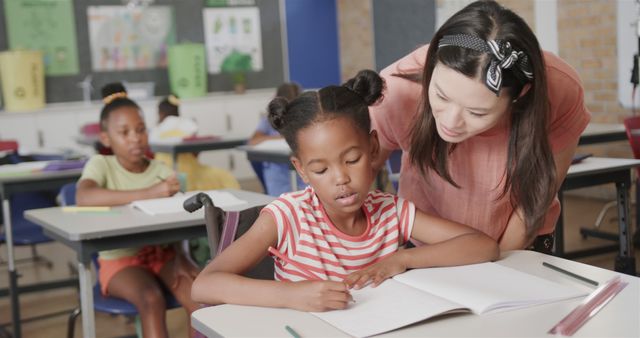 Teacher Guiding Young Student in Classroom - Download Free Stock Images Pikwizard.com