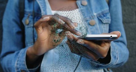 Woman tapping smartphone in denim jacket displaying holographic point cloud ai avatar