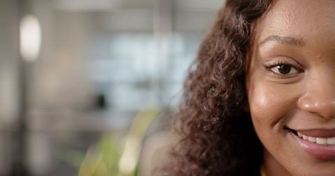 Close-Up of Smiling Woman with Curly Hair in Office