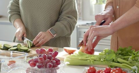 Couple Chopping Fresh Vegetables and Fruits in Modern Kitchen