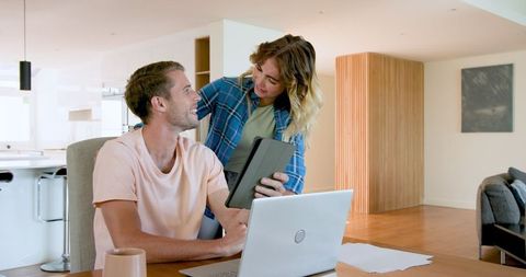 Couple collaborating with technology at home
