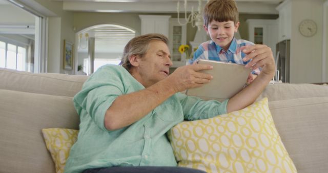 Grandfather and Grandson Using Digital Tablet on Couch - Download Free Stock Images Pikwizard.com