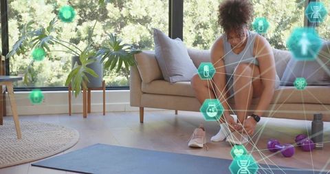 Woman tying sneakers before home workout with ar health icons, yoga mat, dumbbells
