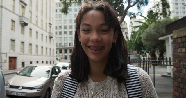 Smiling Teenager with Backpack in Urban Setting - Download Free Stock Images Pikwizard.com