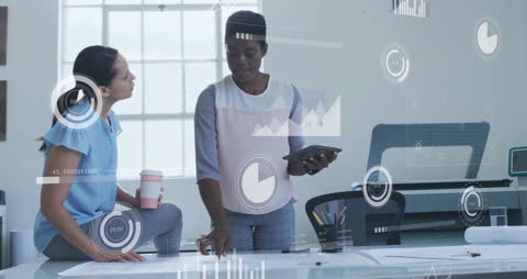 Colleagues Discussing Work with Financial Data Overlays in Modern Office