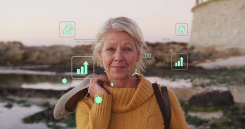 Senior woman standing on rocky shore at sunset holding shoe on shoulder with eco data overlays