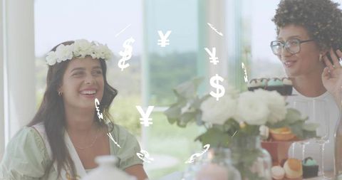 Smiling friends sharing tea and desserts at bridal shower with currency symbols overlay
