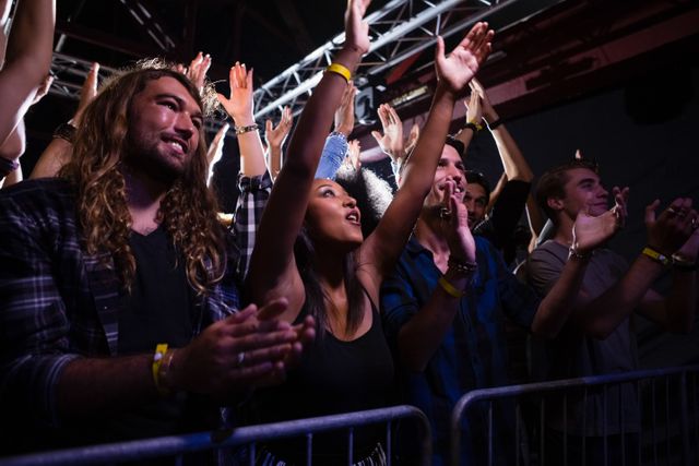 Crowd dancing and enjoying a rock concert in nightclub