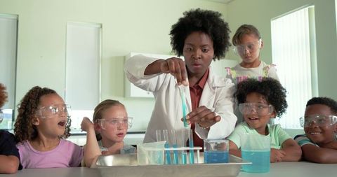 African American teacher leading chemistry experiment with excited diverse children