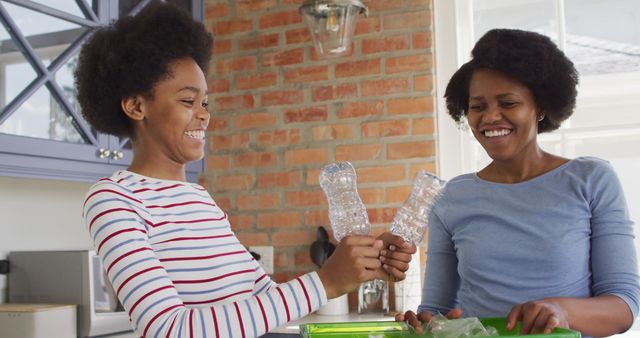 Mother and daughter bonding while participating in a sustainable activity in the kitchen. Ideal for promoting environmental awareness, family values, and sustainable living. Can be used in advertisements, blogs, and educational materials related to recycling and eco-friendly habits.