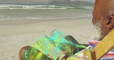 Senior Man Reading Book on Beach with Holographic Technology