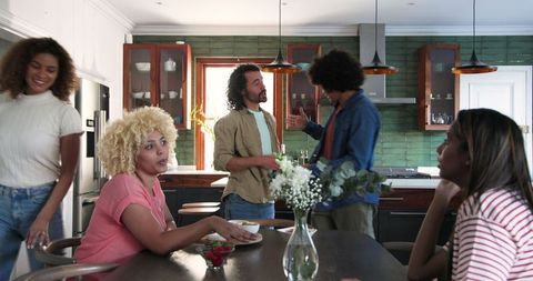 Friends Celebrating in Modern Kitchen with Drinks and Laughter