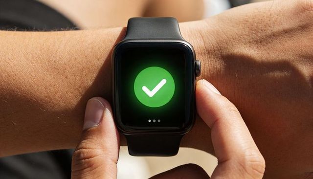 Tapping smartwatch showing green checkmark on wrist for contactless confirmation