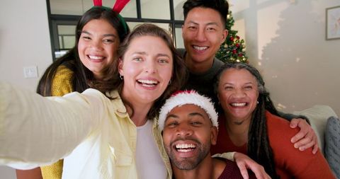 Cheerful Friends Taking Selfie in Festive Living Room with Christmas Tree