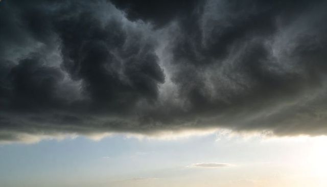 Dark Cumulonimbus Shelf Cloud Looming Over Pale Horizon at Approaching Storm Front