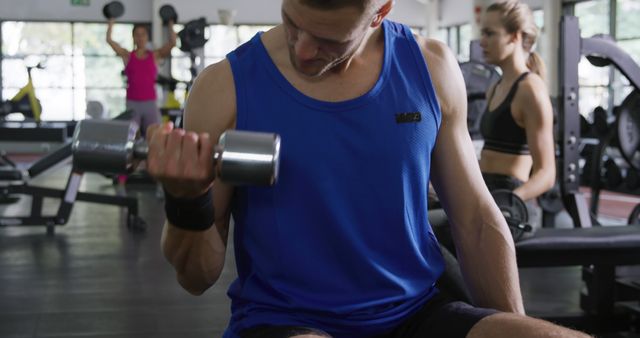 Man Lifting Dumbbell in Gym with Focused Expression - Download Free Stock Images Pikwizard.com