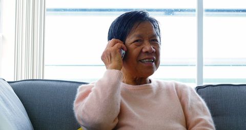Senior Woman Engaging in Friendly Conversation on Mobile Phone