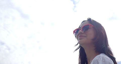 Smiling Teen with Sunglasses Relaxing Outdoors on Sunny Day