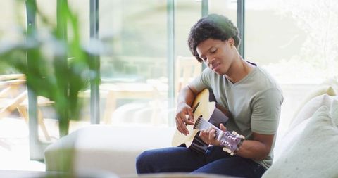 African American Man Playing Guitar at Home in Relaxed Atmosphere - Download Free Stock Images Pikwizard.com