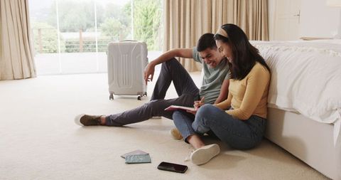 Couple on bedroom floor planning exciting travel adventure