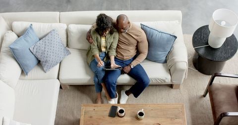 Happy Couple Relaxing with Tablet on Stylish Couch - Download Free Stock Images Pikwizard.com
