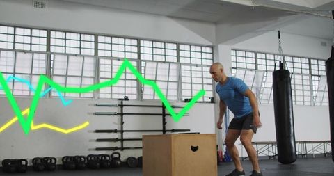 Middle-aged man stepping onto plyometric box during functional fitness workout