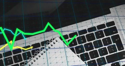 Futuristic data analytics with neon line graphs over laptop keyboard and notebook