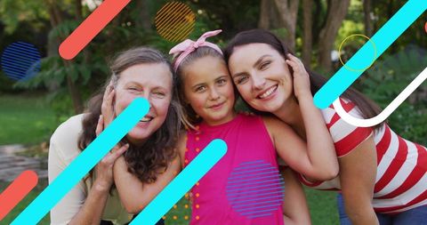 Three generations embracing in sunlit backyard smiling mother daughter grandmother bonding