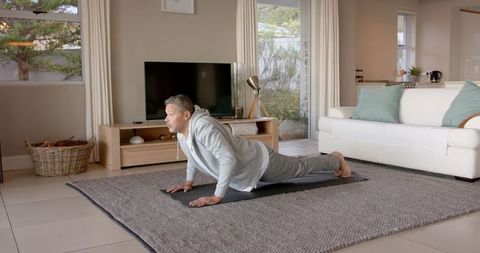 Senior Man Practicing Yoga in Cozy Living Room Setting