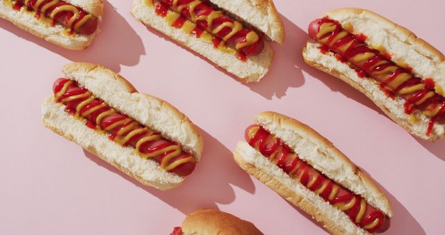Image of hot dogs with mustard and ketchup on a pink surface - Download Free Stock Photos Pikwizard.com
