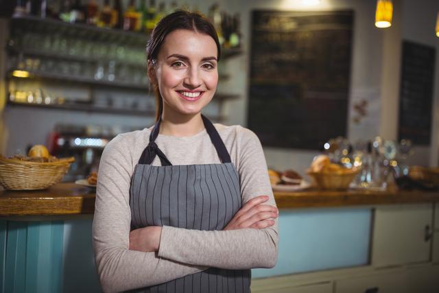 Portrait of smiling waitress standing at counter in cafe